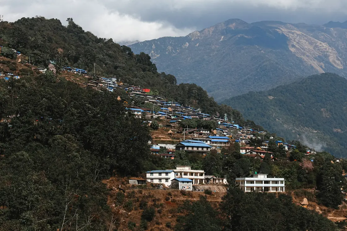 Houses on a hillside with mountains in the background in Nepal